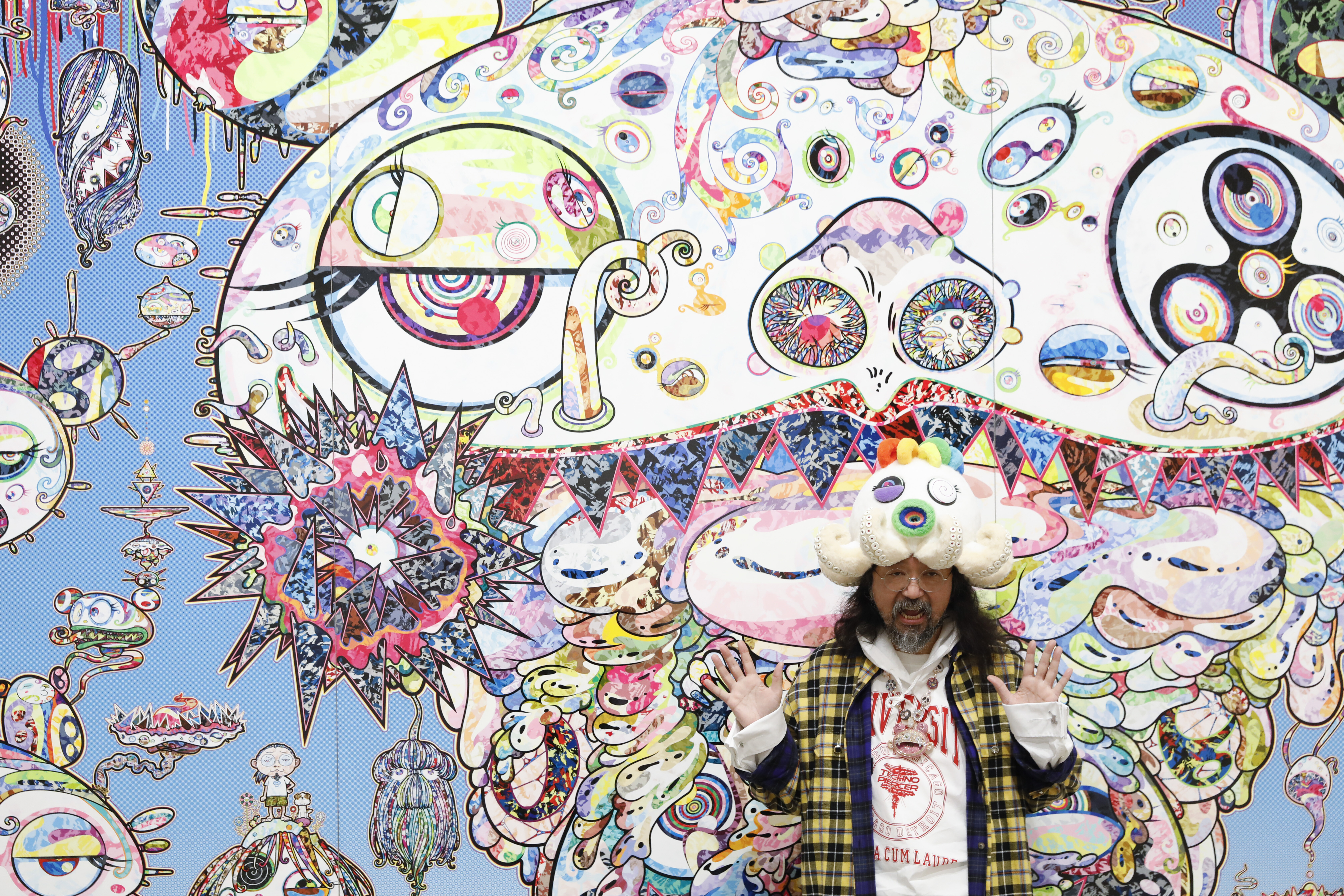 Takashi Murakami standing in front of one of his artworks at The Broad